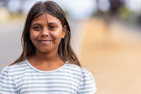 aboriginal girl with stray hair on face and blurry background