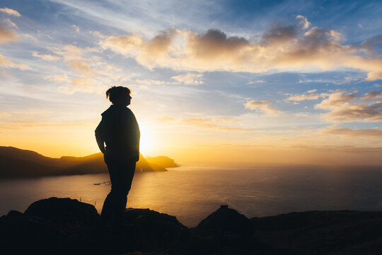 sunrise, dawn against the backdrop of mountains and ocean with the silhouette of a woman