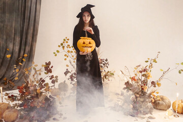 Woman in witch costume with pumpkin