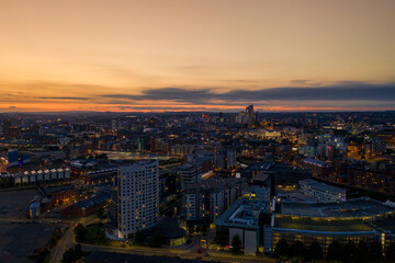 Fototapeta na wymiar Aerial night time photo taken at sunset of the area in Leeds known as The Leeds Dock showing the whole of the West Yorkshire city with the sun setting in the background