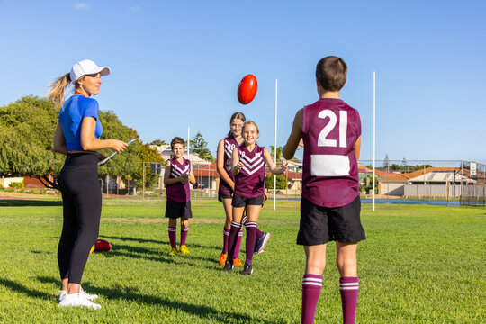 woman wearing activewear supervising kids football training