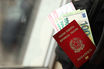Fototapeta premium Italian passport and euro money bills with airline tickets on backpack close up