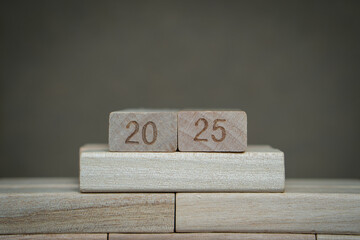 Number 2025 on wooden blocks with gray background. A concept of upcoming 2025 new year planning and goals. 