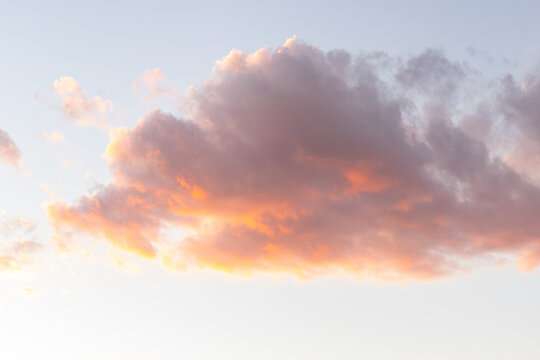 one cloud floating in the sky at sunset