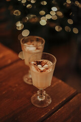 Traditional fall and winter cocktails, alcohol or not. Two glasses of eggnog cocktails with cacao and marshmallow