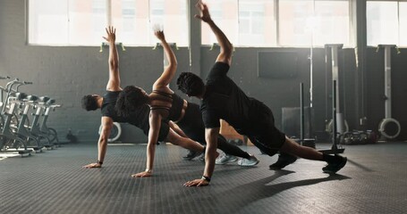 Teamwork, fitness and coach with people for gym, exercise or workout with side plank for sport. Partnership, personal trainer and athletes in gymnasium for wellness, training or health with diversity