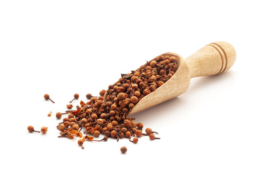 Front view of a wooden scoop filled with Organic Ceylon Ironwood or Nagkesar (Mesua ferrea) seeds. Isolated on a white background.