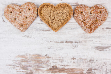Fresh wholegrain bread in shape of heart for breakfast. Place for text on rustic background