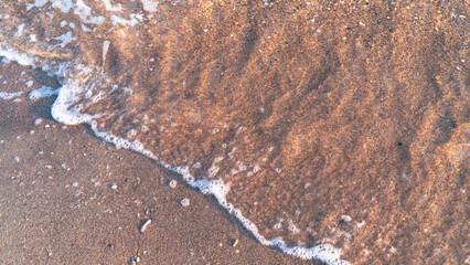 Sandy beach background with sea waves.