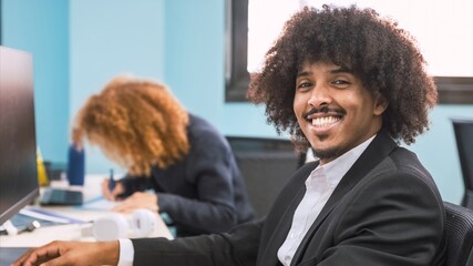 Happy confident creative businessman using computer in office