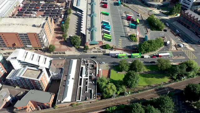Aerial footage of the Leeds City Centre on a hot sunny summers day showing with the drone hovering over the bus station showing busses leaving and parking up at the bus stop