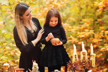 Mother and daughter preparing witch potion on Halloween day