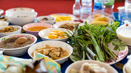 Close-up view of boiled eggs, curry, boiled, stir-fried and many other dishes packed in bowls.