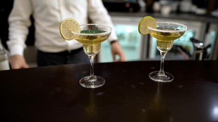 Bar counter and two martini glasses. Waiter and martini glasses.