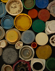 A collection of caps and lids of various colors and sizes. Concept of disarray and chaos, as the caps and lids are scattered all over the surface