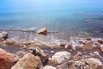  Top view of clear blue water and stones by the sea in Menton, France
