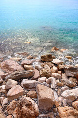 Top view of clear blue water and stones by the sea in Menton, France