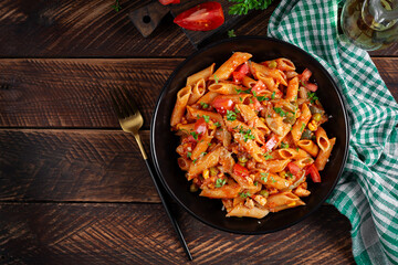 Classic italian pasta penne arrabbiata with vegetables on wooden table. Penne pasta with sauce arrabbiata. Top view, overhead - 784438193