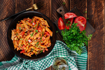Classic italian pasta penne arrabbiata with vegetables on wooden table. Penne pasta with sauce arrabbiata. Top view, overhead - 784438329