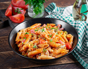 Classic italian pasta penne arrabbiata with vegetables on wooden table. Penne pasta with sauce arrabbiata. Top view, overhead - 784438359