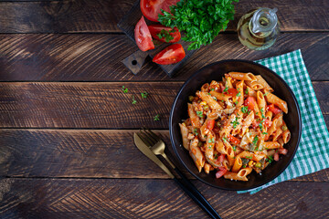 Classic italian pasta penne arrabbiata with vegetables on wooden table. Penne pasta with sauce arrabbiata. Top view, overhead - 784439119