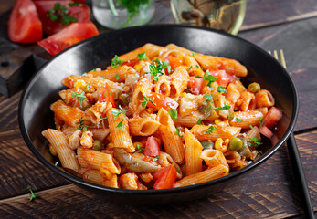 Classic italian pasta penne arrabbiata with vegetables on wooden table. Penne pasta with sauce arrabbiata. Top view, overhead - 784439354