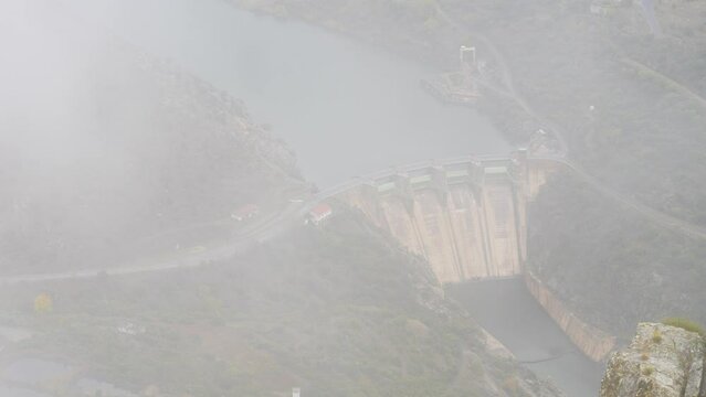 Mountain and Douro river with spanish Saucelle Dam at foggy cloudy weather. Border between Portugal and Spain. National Parks. View from portuguese Penedo Durao lookout.