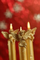 Fototapeta premium Close up of three candles with angels, perfect for religious events