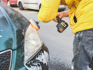 A young caucasian guy without a face in a yellow jacket is being drilled with a sponge disc and...
