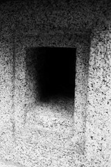 window in old stone wall in black and white