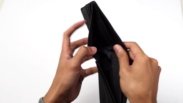 a man's hand holds an empty wallet that has no money in it. wallet for money. with white background