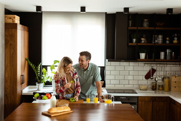 Joyful Couple Sharing a Moment Over Breakfast in a Modern Kitchen