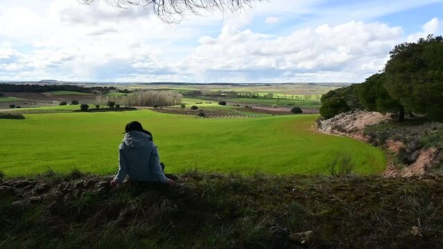 Woman sitting contemplating the landscape