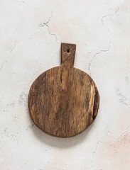 An empty wooden cutting board in rustic style on a light background, top view. Food background