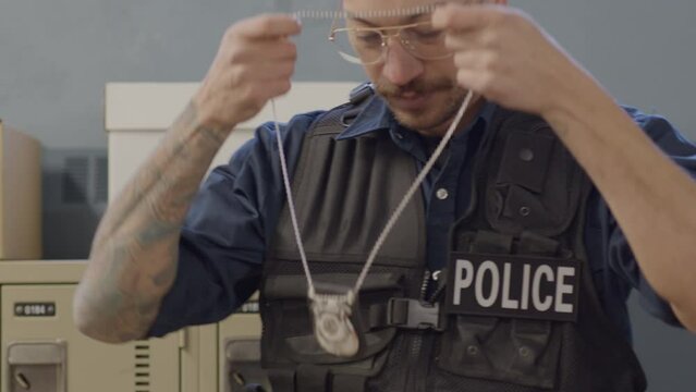 Police officer putting on badge close up
