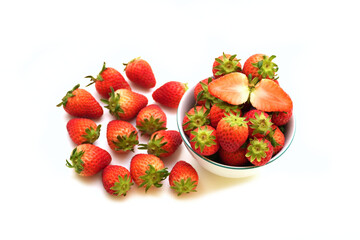 Many Strawberries fruit in and out beside bowl.