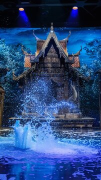 A stage play of a Songkran story set against a massive backdrop painting of a Thai temple