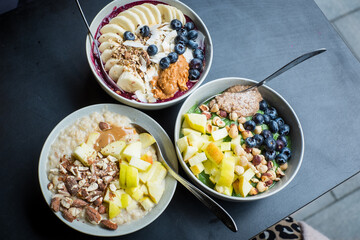 Assortment of different smoothie bowls and porridges with fresh toppings.