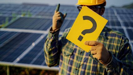 A PV installer with solar panels and question mark poster.