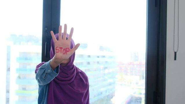 A Muslim woman with belo with the palm of her hand wrote the word stop stop. Equal rights, non-discrimination, no Islamophobia, no racism and discrimination. Effective equality of rights and equity be