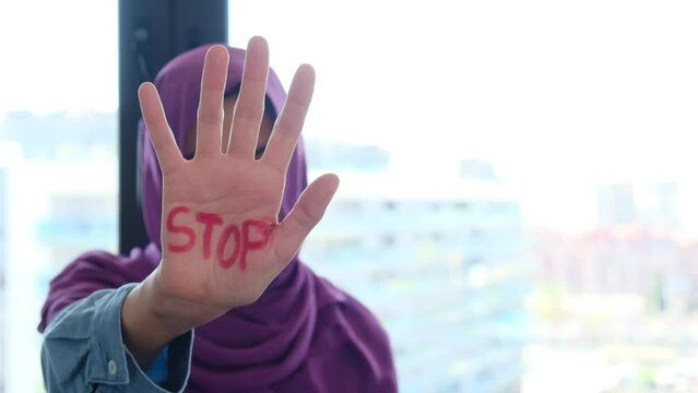 A Muslim woman with belo with the palm of her hand wrote the word stop stop. Equal rights, non-discrimination, no Islamophobia, no racism and discrimination. Effective equality of rights and equity be