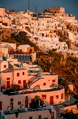 Häuser, Bungalows in Thera bzw. Oia, zwei kleine Dörfer auf dem Kraterrand der griechischen Insel Santurin im ägäischen Meer im warmen Abend-oder Morgenlicht der Sonne