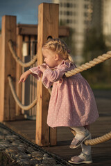 Little explorer on a bridge, pausing to ponder. A snapshot of innocence and the early years of discovery.