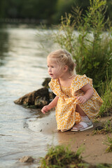 Curious child at the riverbank, in a moment of exploration. Highlights the wonder in everyday natural experiences.