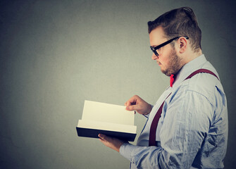 Side profile of a business man reading a book  - 784497573