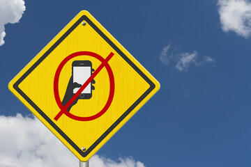 No texting or cell phone while driving symbol on warning road sign - 784501120