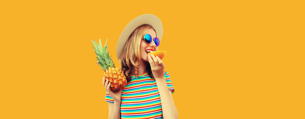 Summer portrait of happy smiling young woman with pineapple fruit on yellow studio background