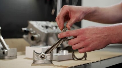 Expert mechanic assembles engine kit, installs pistons, rings in workshop. Auto repair tutorial with hands-on demonstration for vehicle maintenance. Precision, skill shown in engine rebuild process.