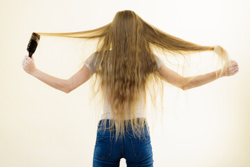 Blonde girl brushing her long hair - 784513917