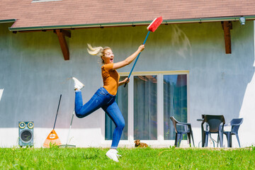 Woman with broom on backyard - 784513927